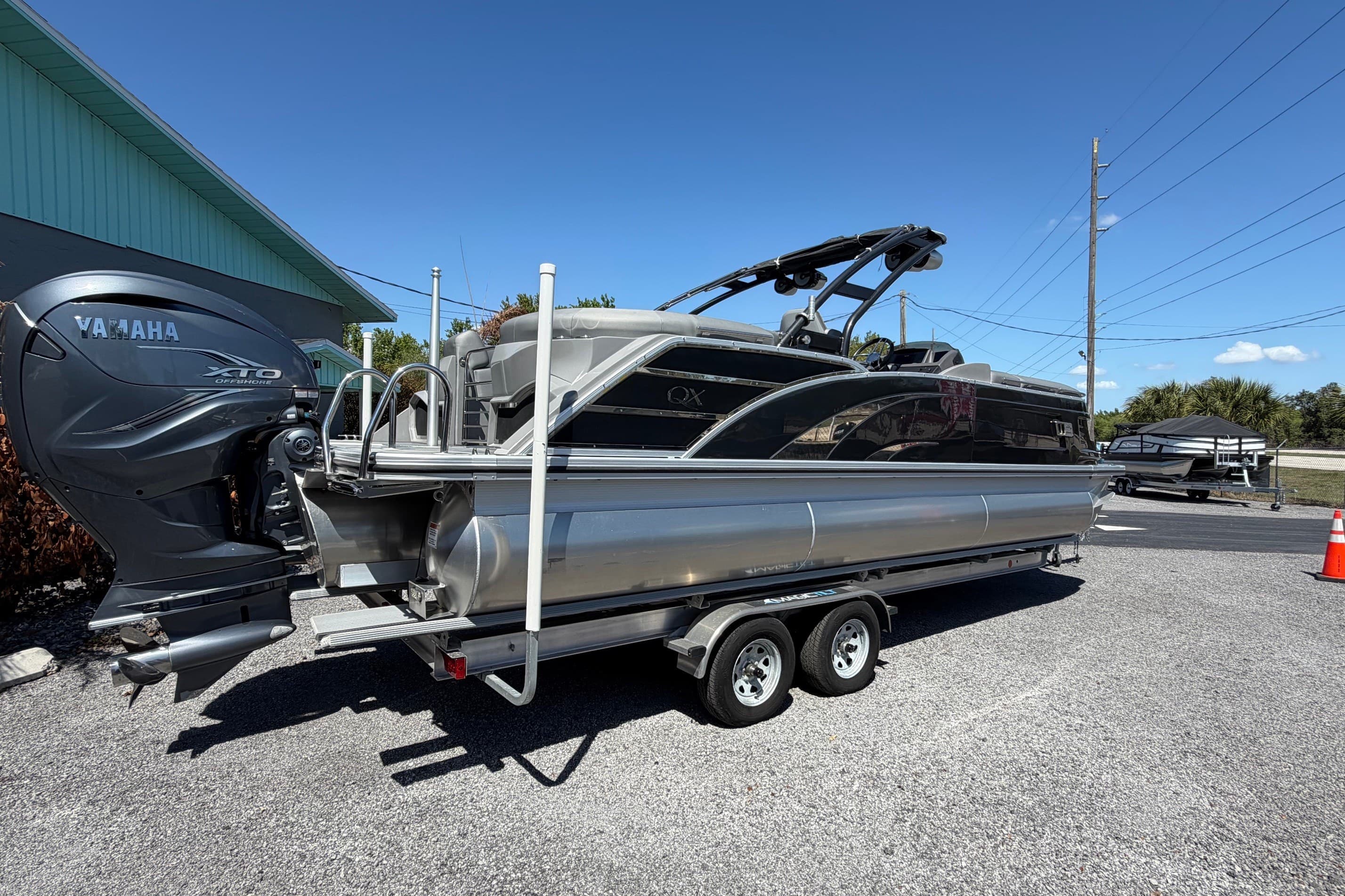 2022 Bennington 25 QX pontoon boat with Yamaha XTO outboard engine on trailer.
