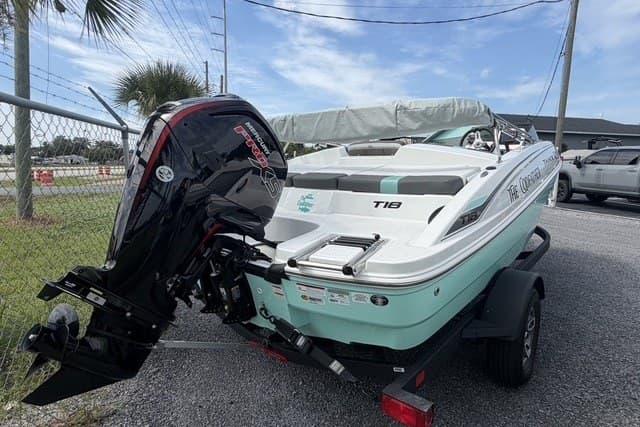 2025 Tahoe T18 boat with outboard motor on trailer, parked outdoors.
