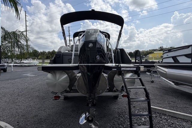 2027 Evotti 523CS boat with outboard motor and ladder, parked on gravel lot.
