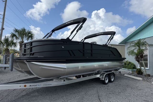 2027 Evotti 523CS pontoon boat on trailer, sleek black design, parked outdoors.