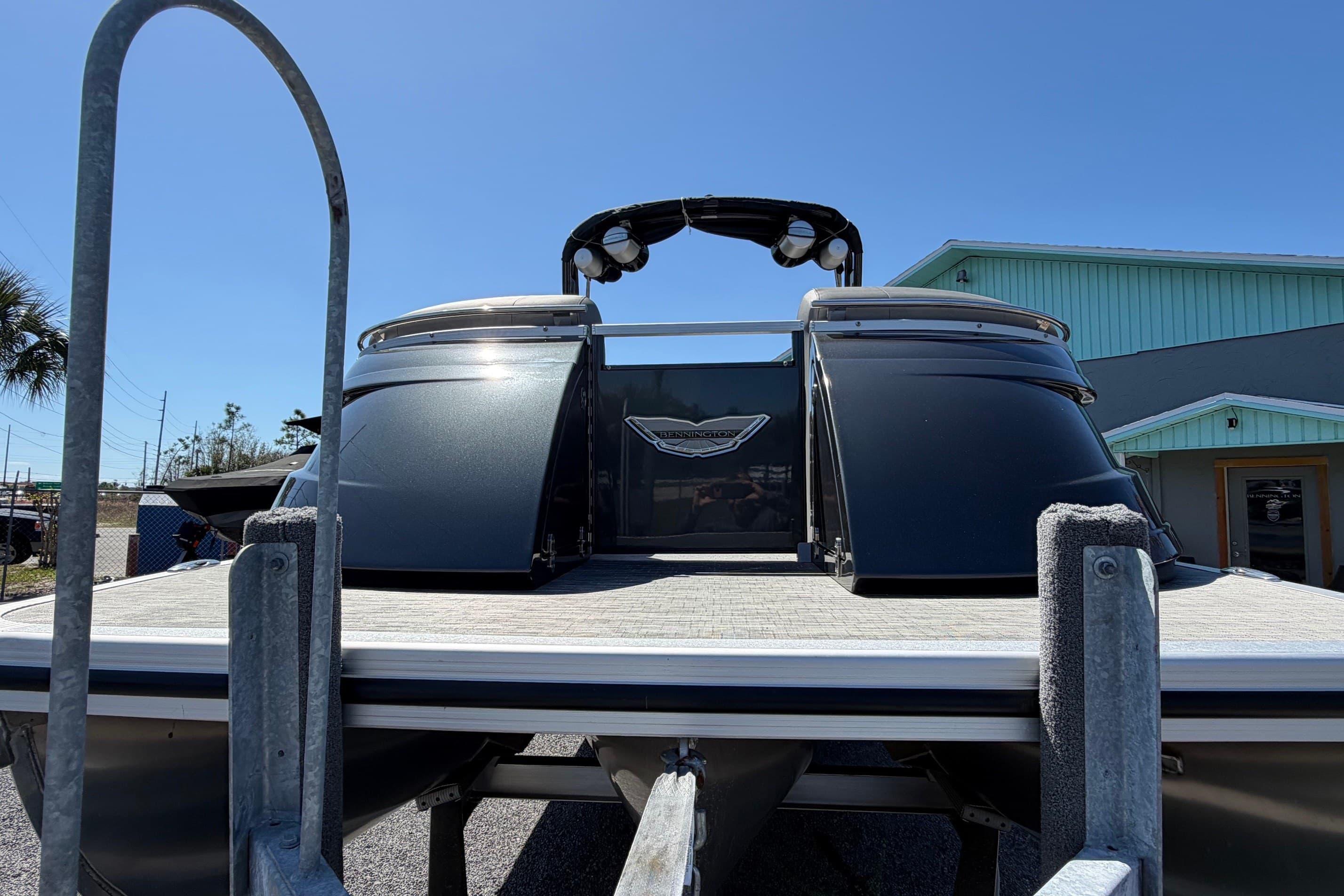 2022 Bennington 25 QX pontoon boat on trailer under clear blue sky.