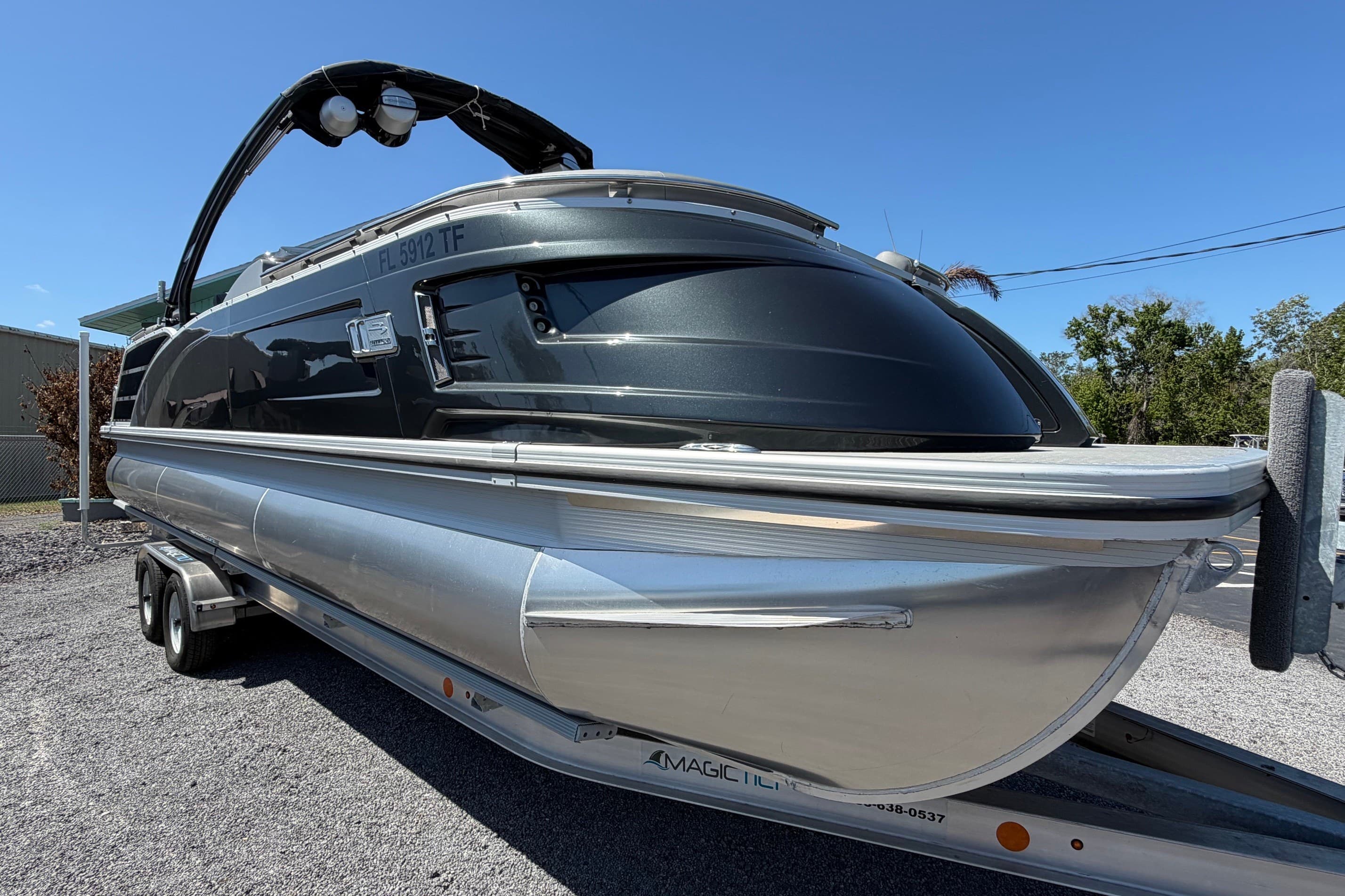 2022 Bennington 25 QX pontoon boat on trailer under clear blue sky.