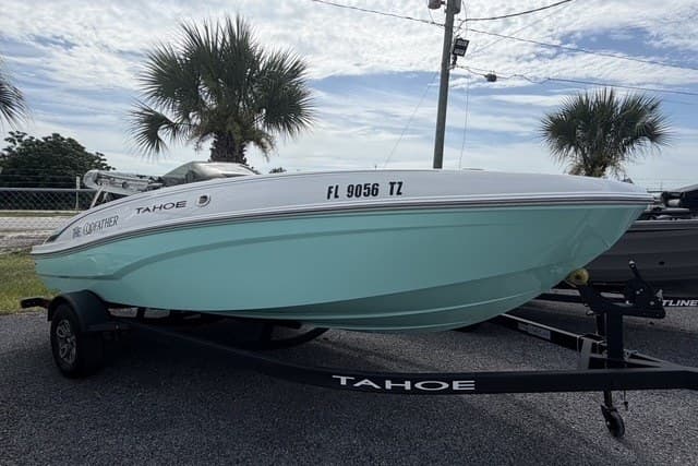 2025 Tahoe T18 boat on trailer, parked outdoors with palm trees in background.
