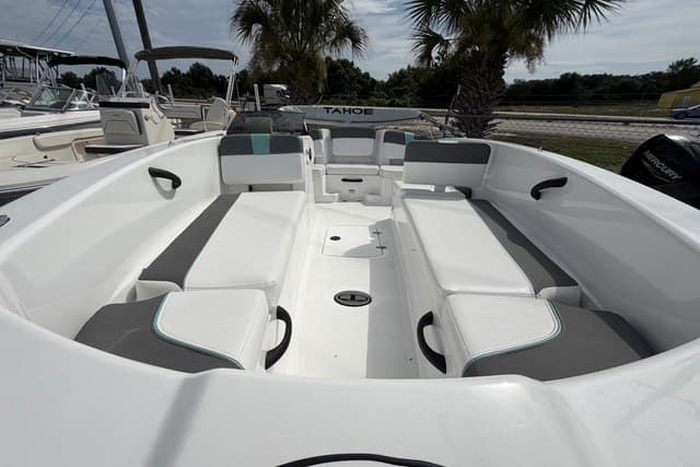 2025 Tahoe T18 boat interior with white and gray seating, palm trees in background.