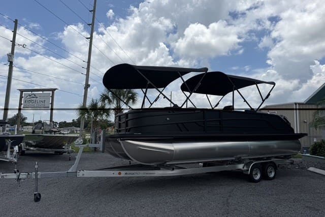 2027 Evotti 523CS pontoon boat on trailer under cloudy sky.
