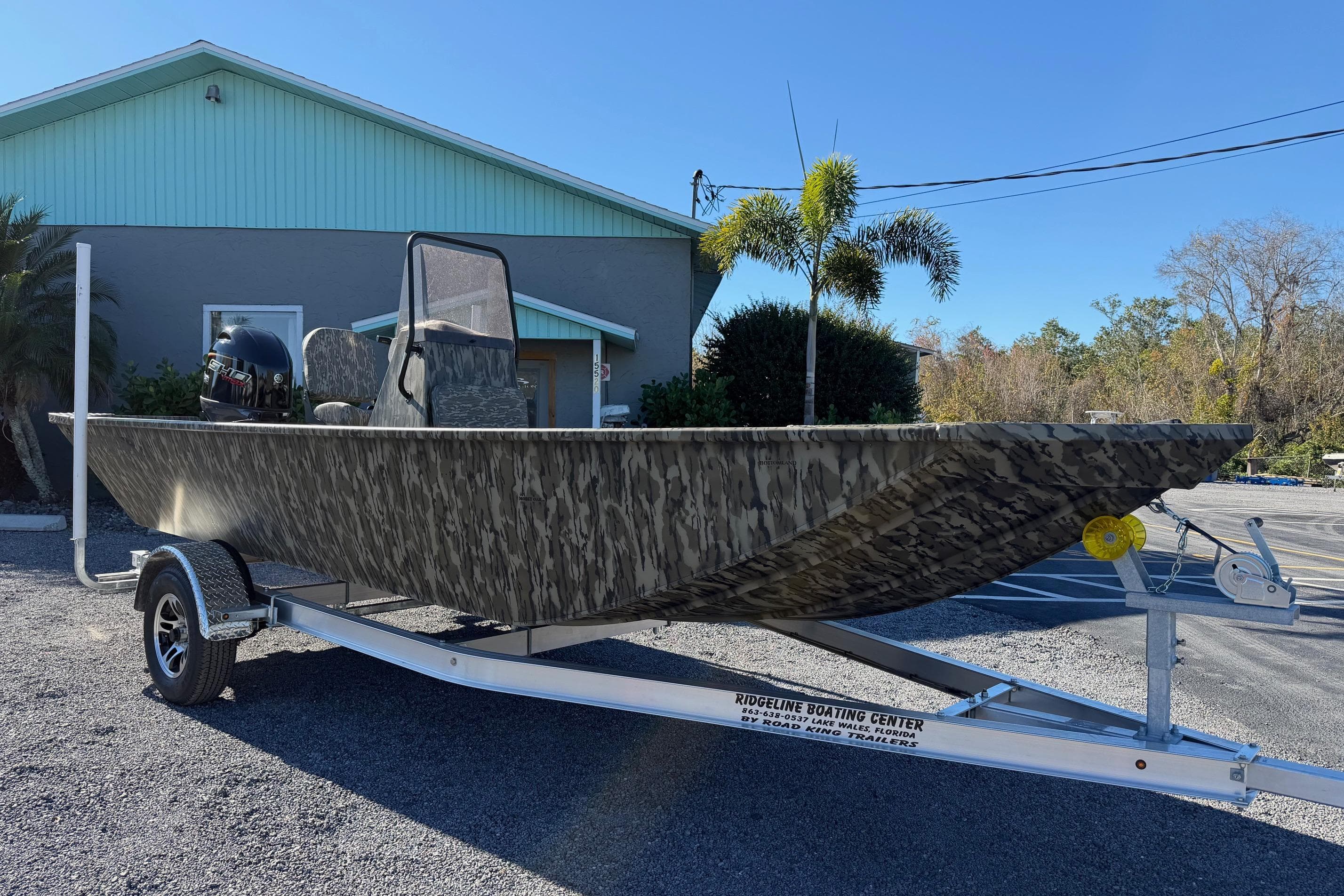 2026 Smoker Craft Sportsman 1866 boat on trailer, camo design, parked outdoors.