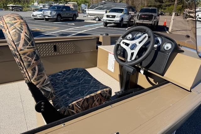 2026 Smoker Craft Pro Sportsman 1660 boat interior with camo seat and steering console.