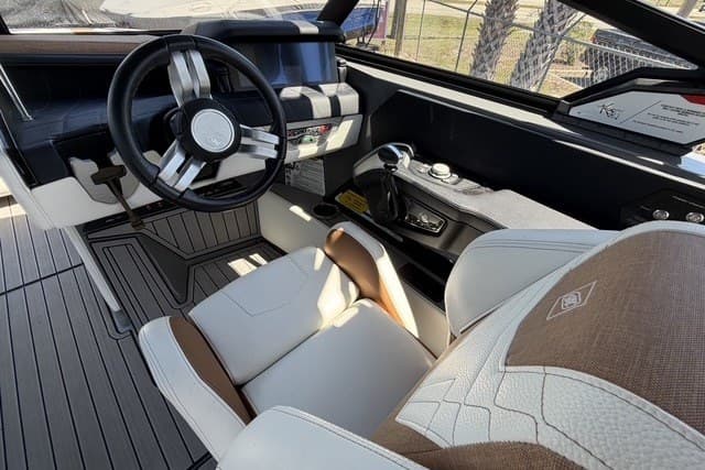 Interior of 2022 Nautique Super Air Nautique G25 boat, featuring modern steering and seating.