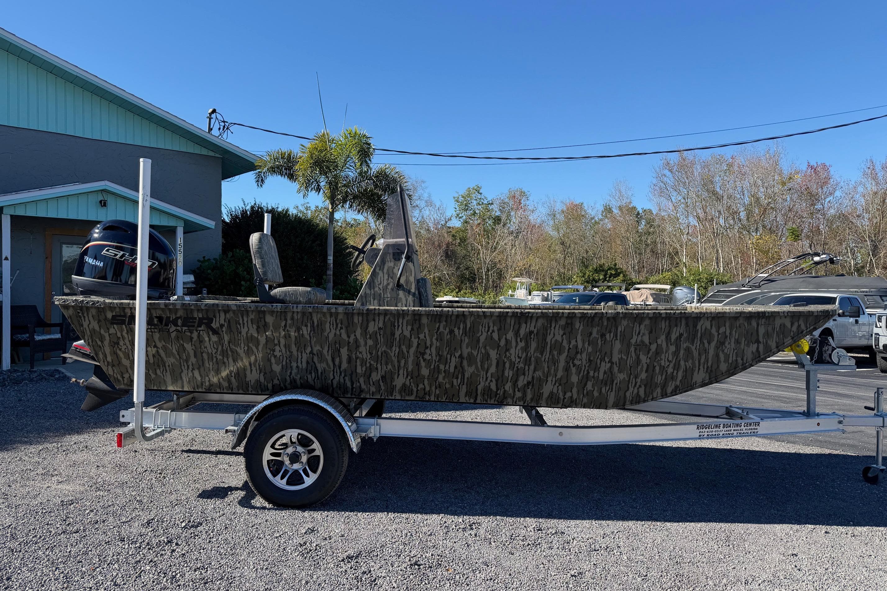 2026 Smoker Craft Sportsman 1866 boat on trailer, camo design, parked outdoors.