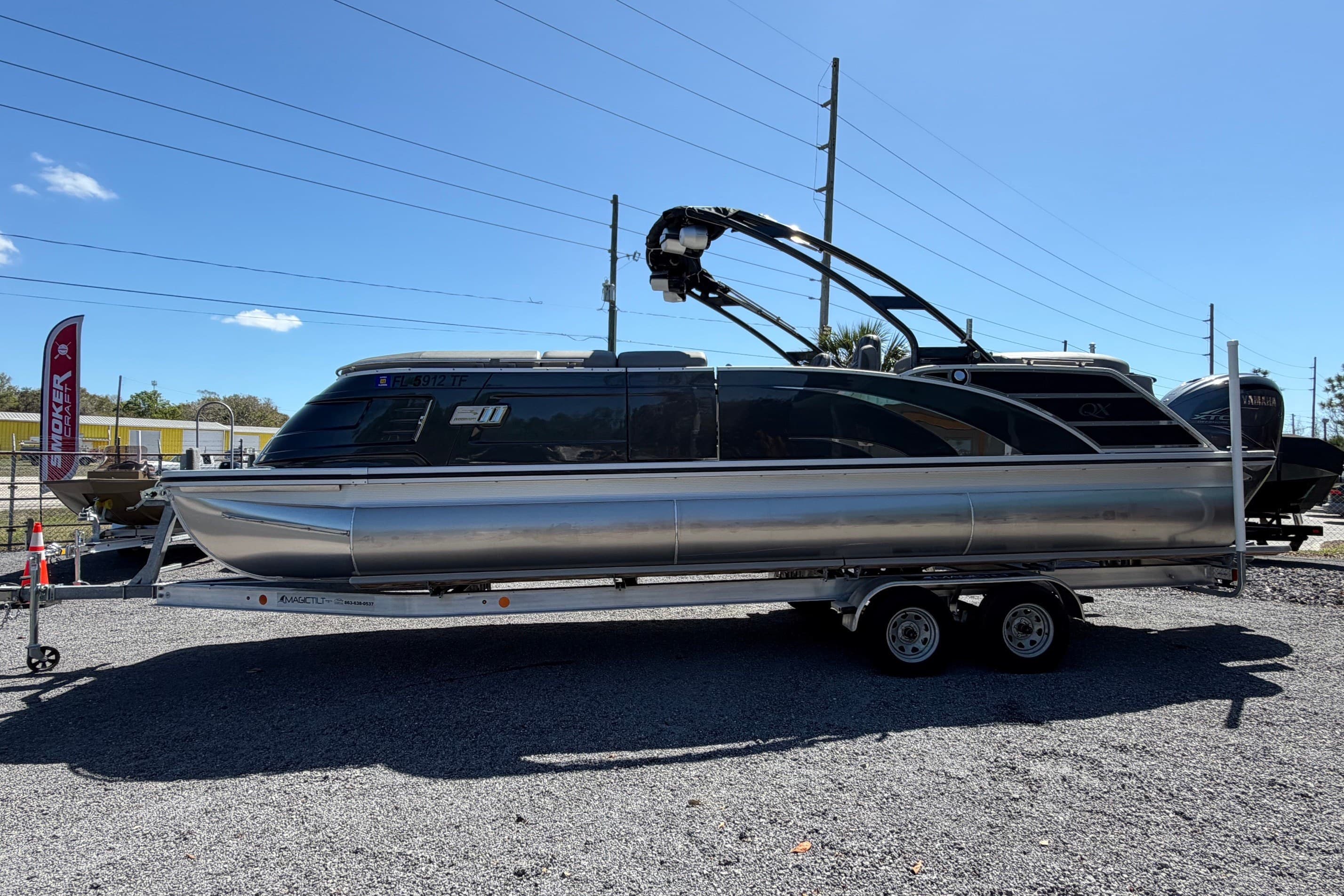 2022 Bennington 25 QX pontoon boat on trailer under clear blue sky.