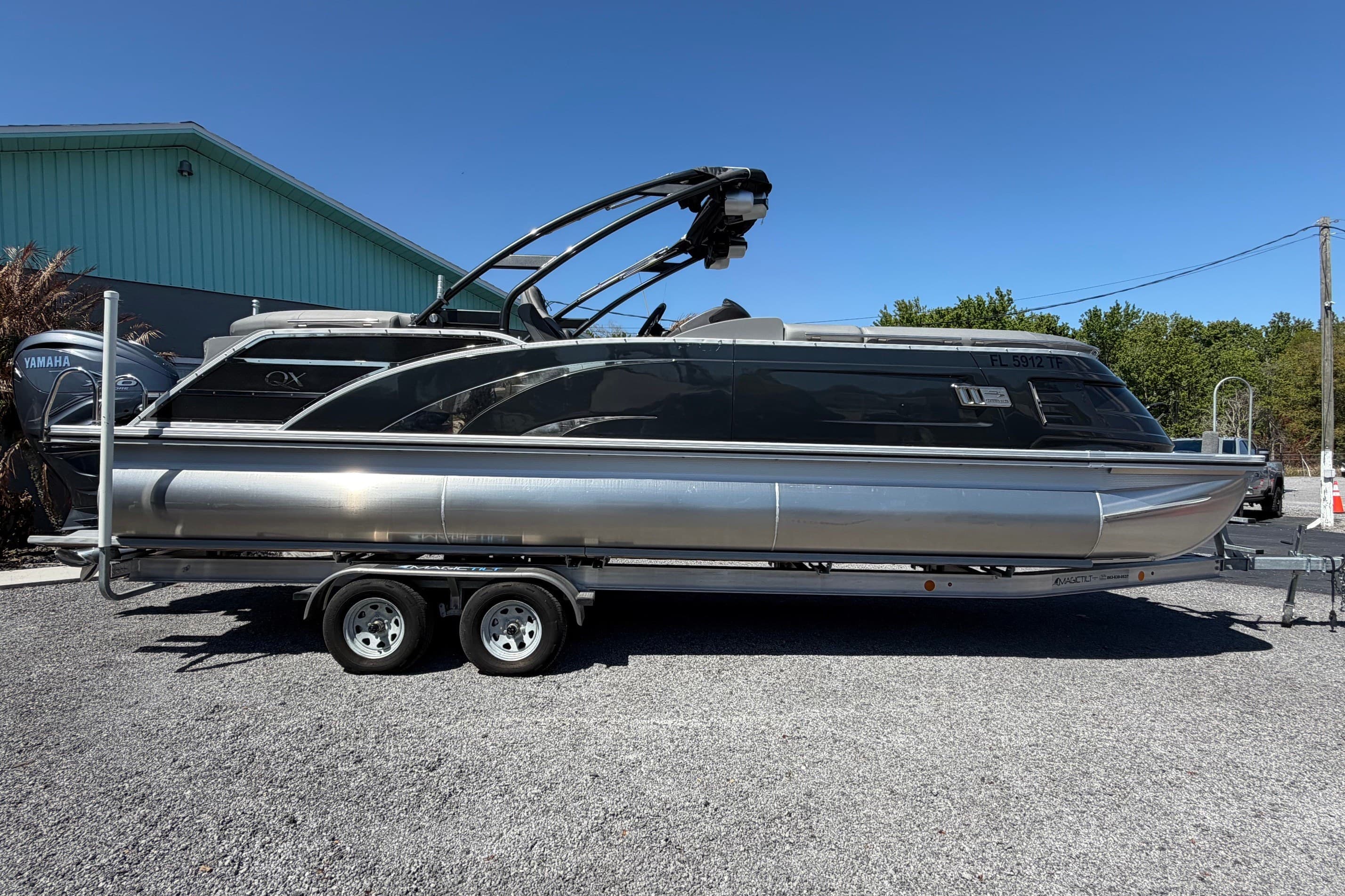 2022 Bennington 25 QX pontoon boat on trailer, parked outdoors.