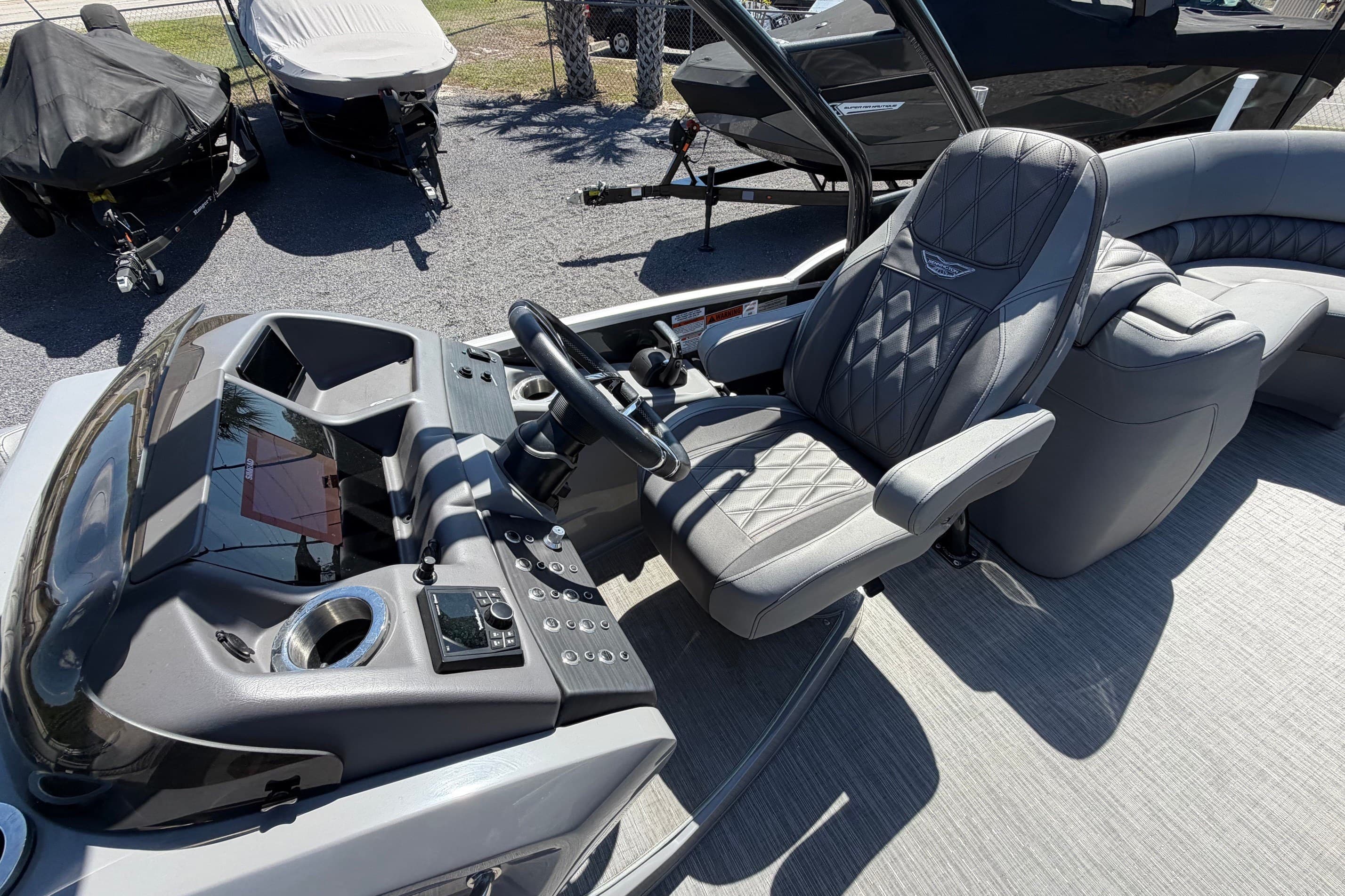 2022 Bennington 25 QX boat interior with luxurious captain's chair and modern dashboard.