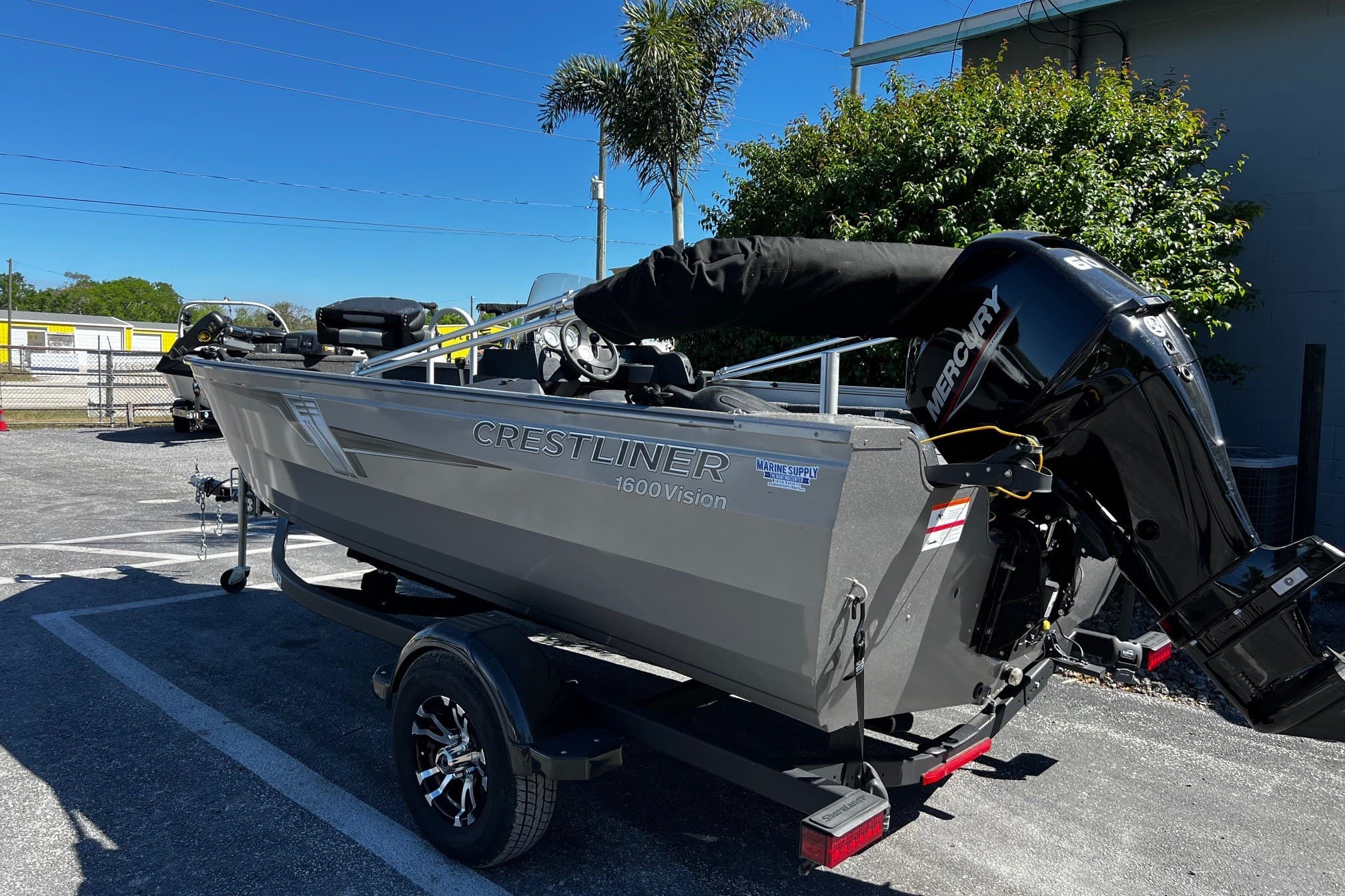 2023 Crestliner 1600 Vision boat on trailer, parked outdoors under clear sky.