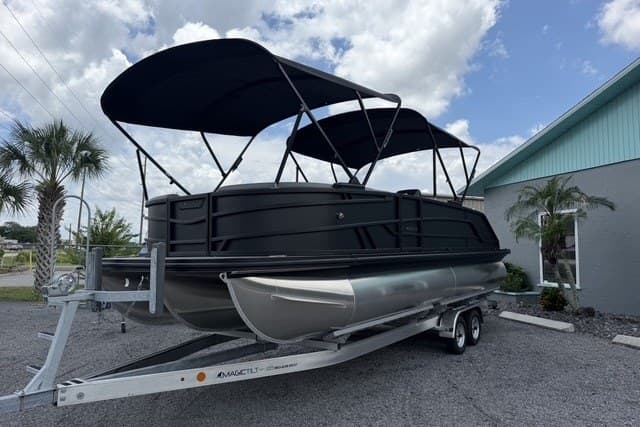 2027 Evotti 523CS pontoon boat on trailer, featuring sleek black design and dual canopies.