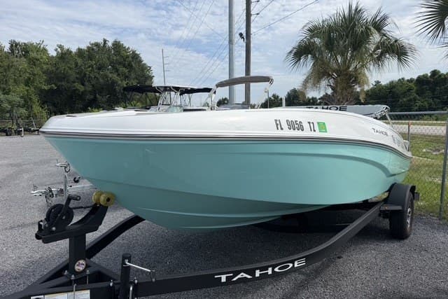 2025 Tahoe T18 boat on trailer, light blue hull, parked outdoors.