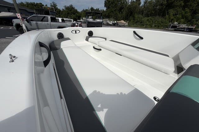2025 Tahoe T18 boat interior with white seating and speakers, parked outdoors.