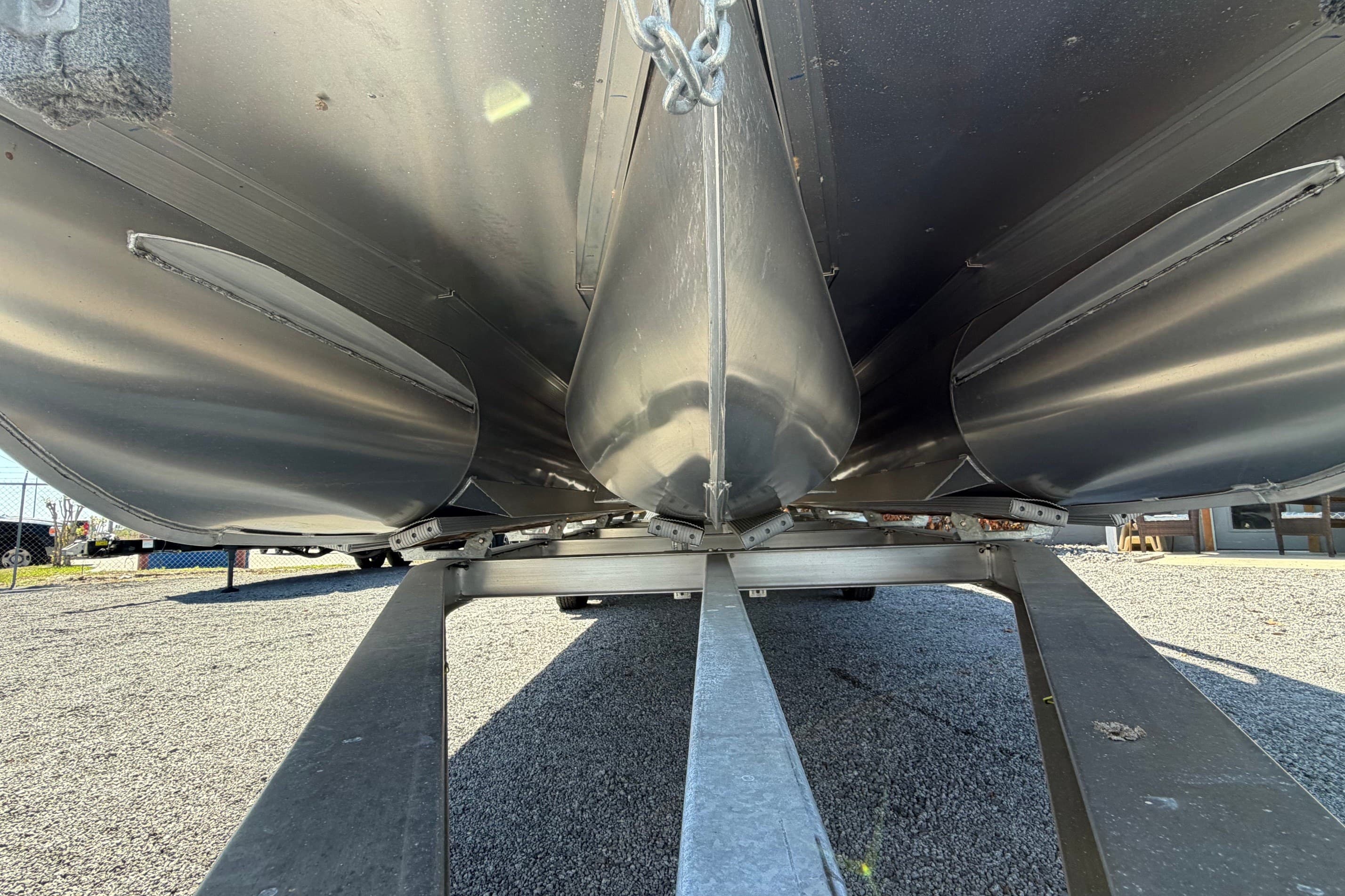 Underneath view of a 2022 Bennington 25 QX pontoon boat on a trailer.