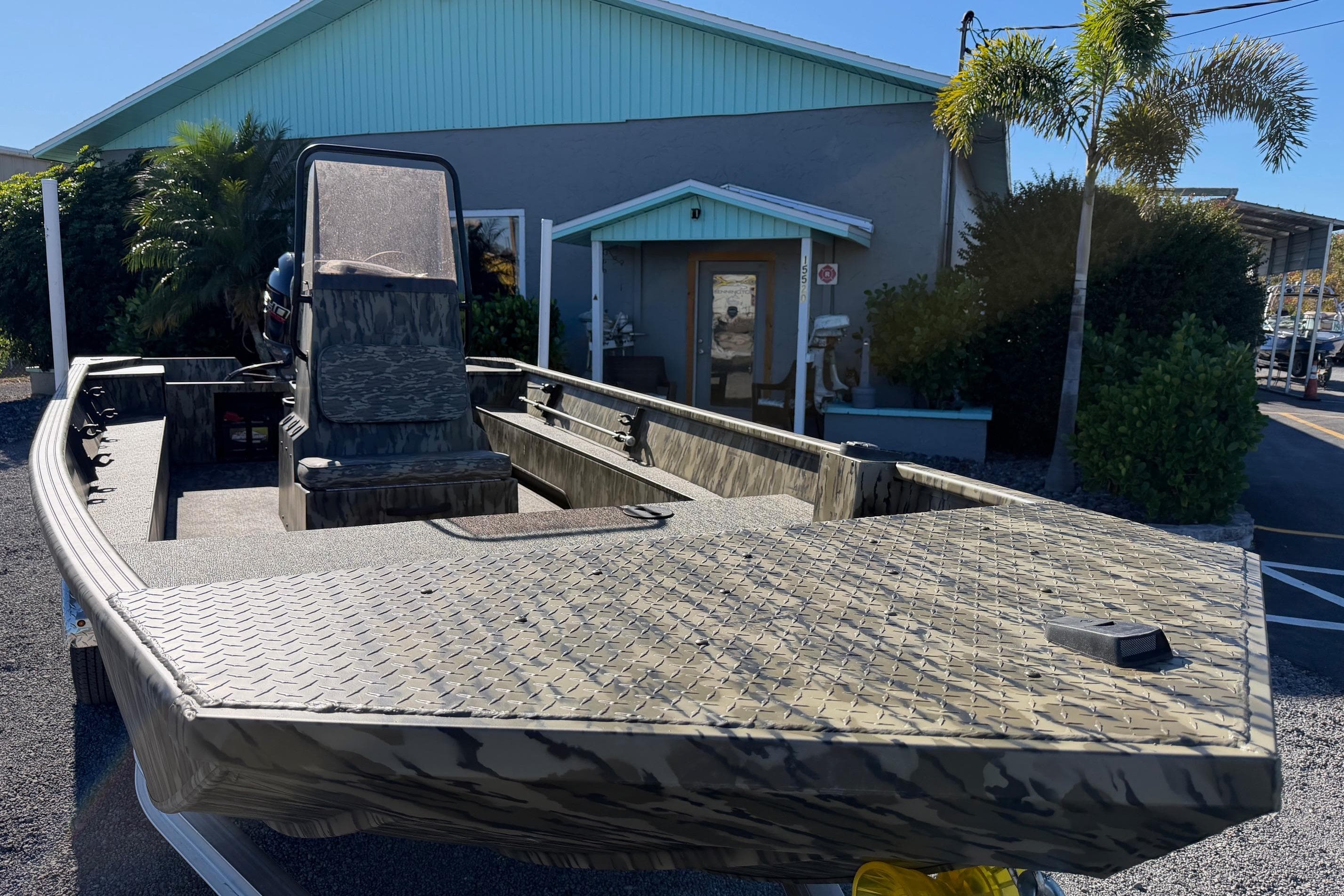 2026 Smoker Craft Sportsman 1866 boat with camouflage design, parked outdoors.