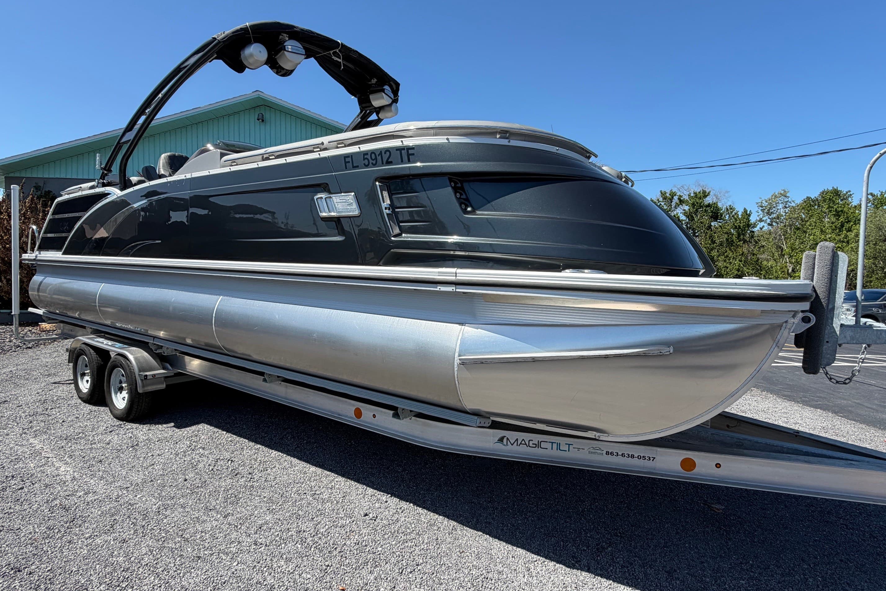 2022 Bennington 25 QX pontoon boat on trailer, parked outdoors.