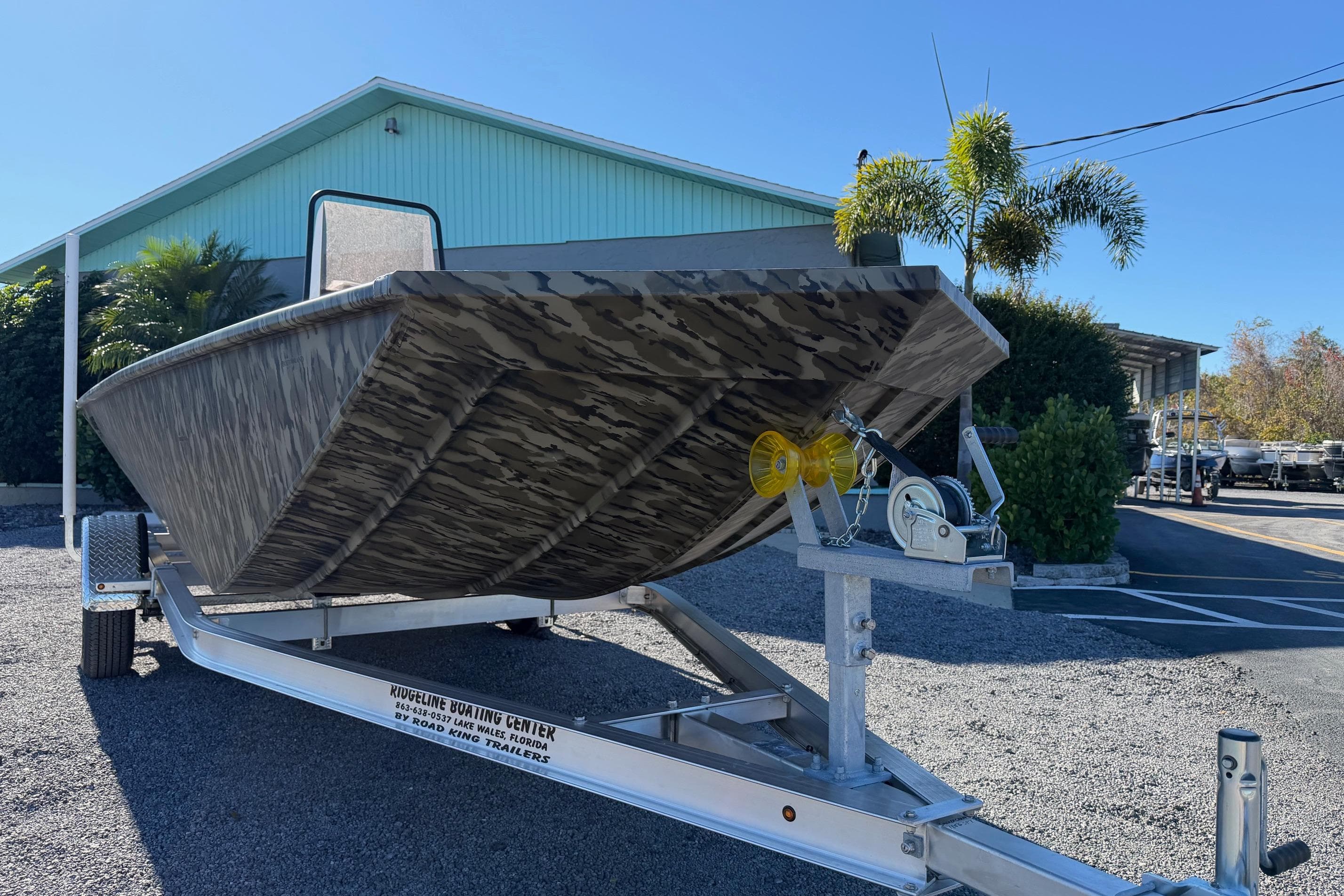 2026 Smoker Craft Sportsman 1866 boat on trailer, camo design, outdoor setting.