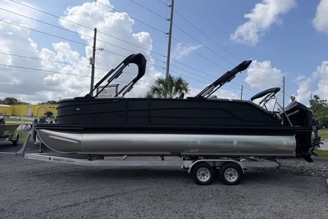 2027 Evotti 523CS pontoon boat on trailer, sleek black design, parked outdoors.
