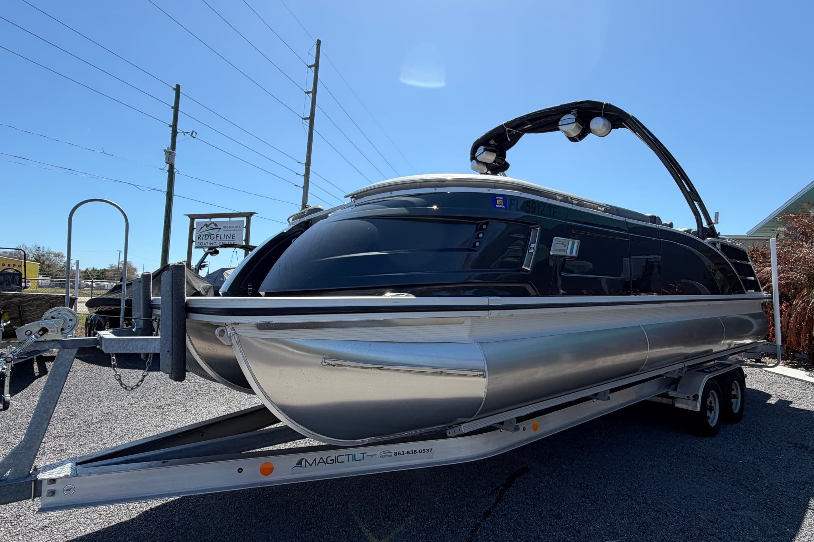 2022 Bennington 25 QX pontoon boat on trailer under clear sky.