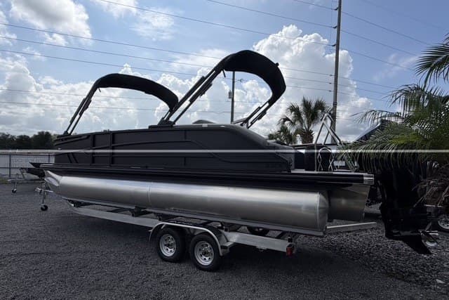 2027 Evotti 523CS pontoon boat on trailer, sleek design, dual bimini tops, parked outdoors.