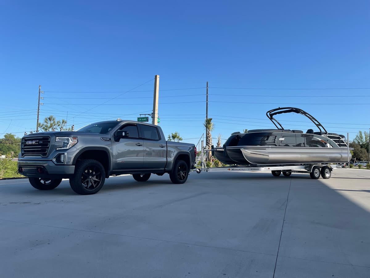 Truck towing a pontoon boat in for service
